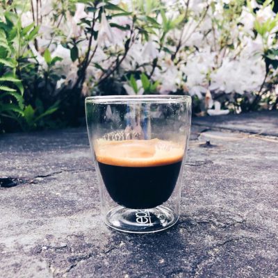 Espresso crema and flowers on pavement