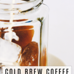 milk being poured into a glass of cold brew coffee with a white background
