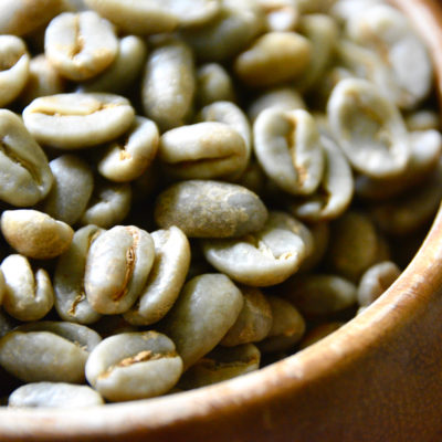 green coffee beans in a wooden bowl