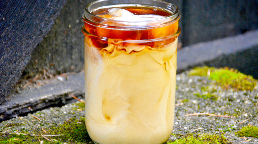 gingerbread iced latte on pavement with moss