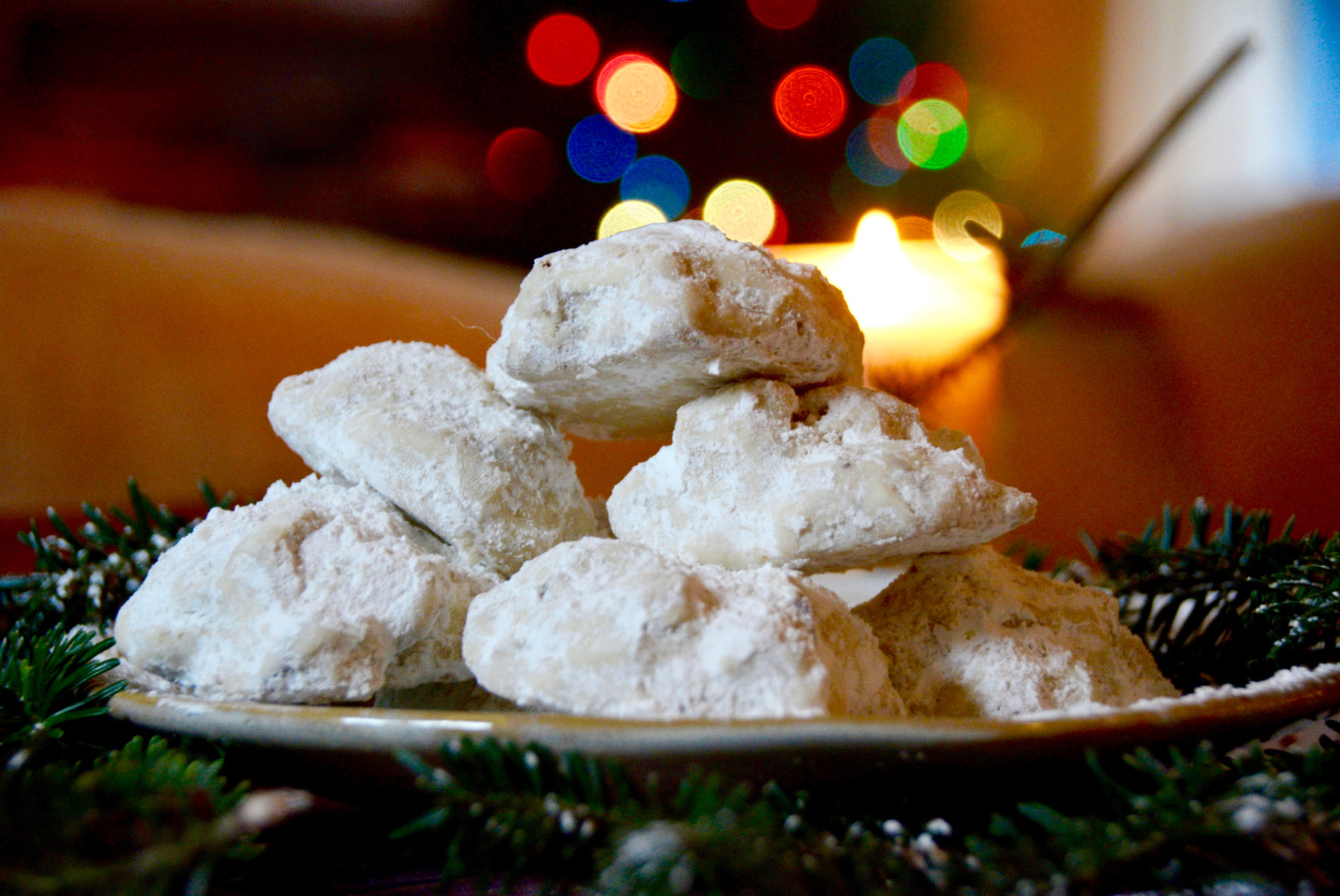 Pecan dreams on a golden plate on a wooden table with pine tree branches and christmas lights in the background