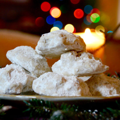 Pecan dreams on a golden plate on a wooden table with pine tree branches and christmas lights in the background