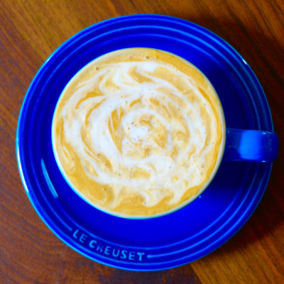 cappuccino in a blue cup with latte art design