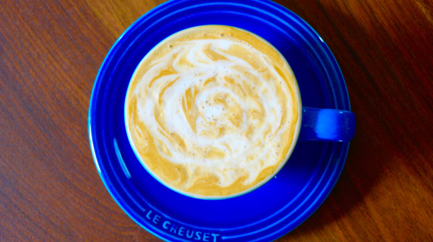 cappuccino in a blue cup with latte art design