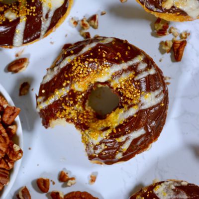 chocolate frosted donuts with gold and white and pecans