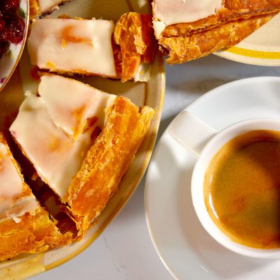 Overhead view of Wisconsin kringle and a cup of coffee on a table, styled as a cozy breakfast at home.