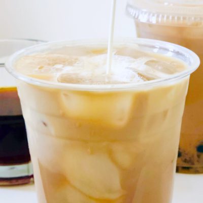 milk being poured into boba coffee plastic cup