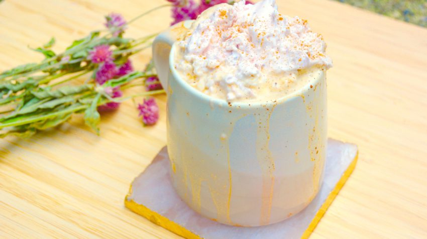 pink mug with strawberry coffee latte and pink dried flowers