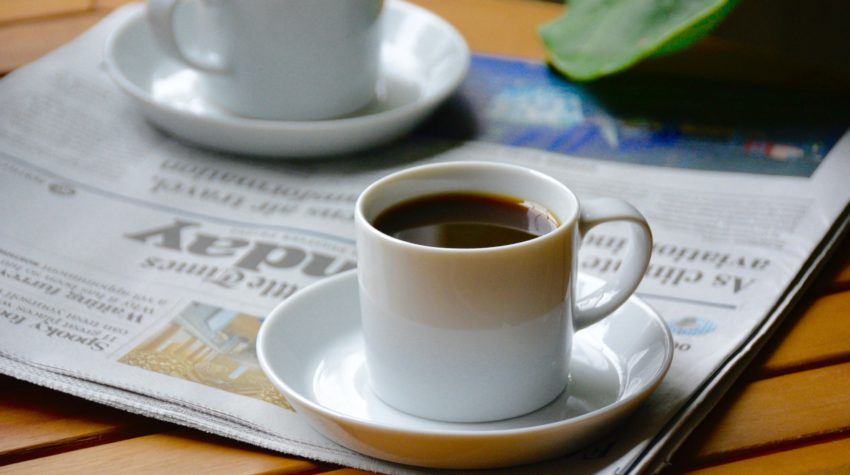 two small cups of coffee on a newspaper