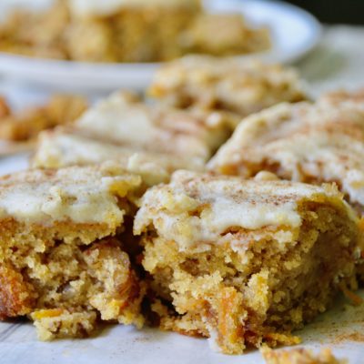carrot cake bars with icing and dusted cinnamon