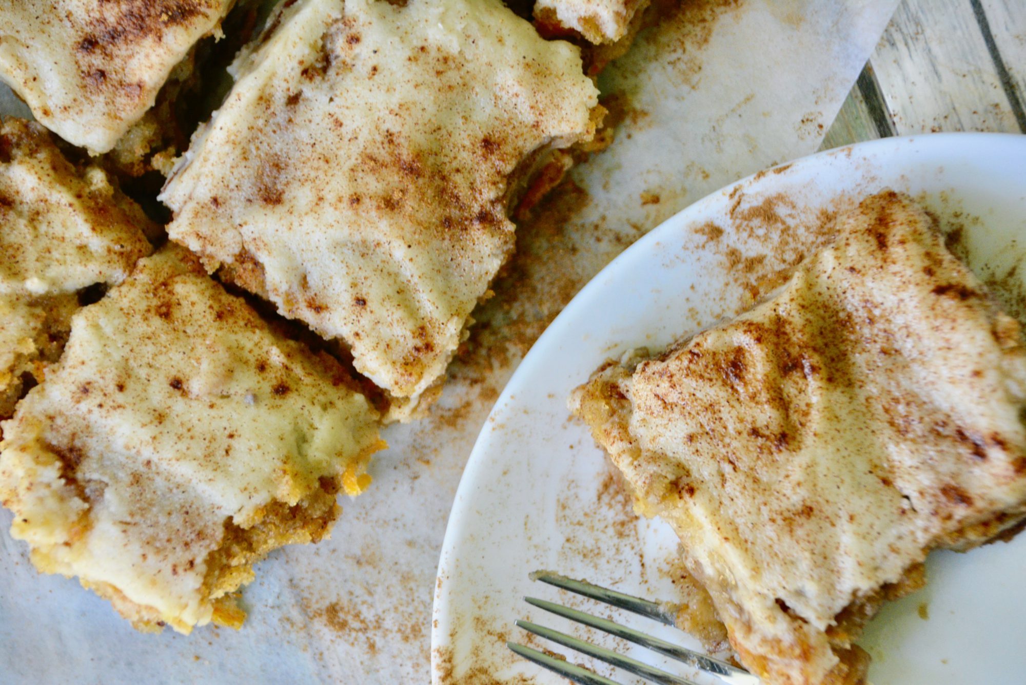 carrot cake bars sliced on white plate